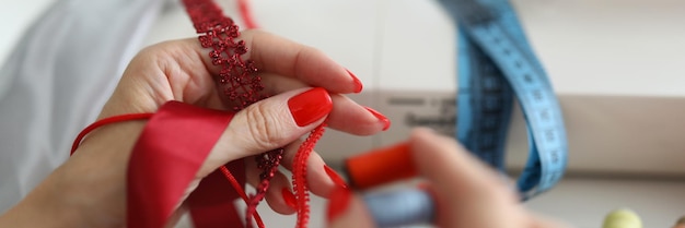 Manos bordando hilo rojo sobre tela