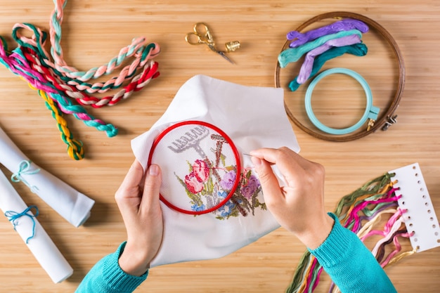 Manos mostrando distintos bordados terminados